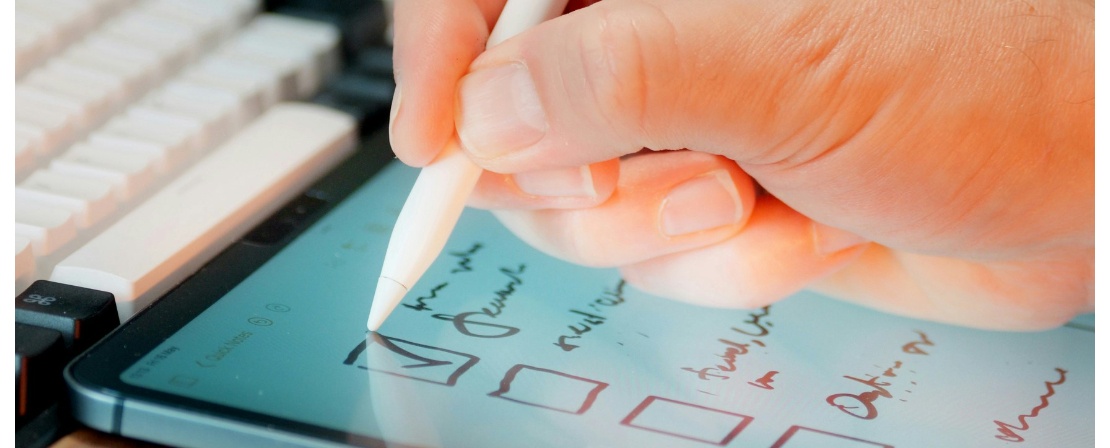 Photographie d'une main écrivant sur une tablette tactile