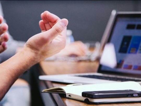 Photo de mains devant un écran d'ordinateur