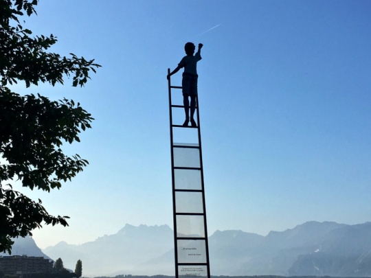 Photographie d'un enfant en haut d'une échelle