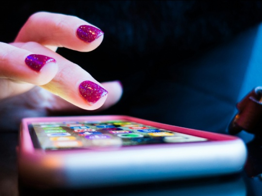 Photographie d'une main appuyant sur un téléphone portable